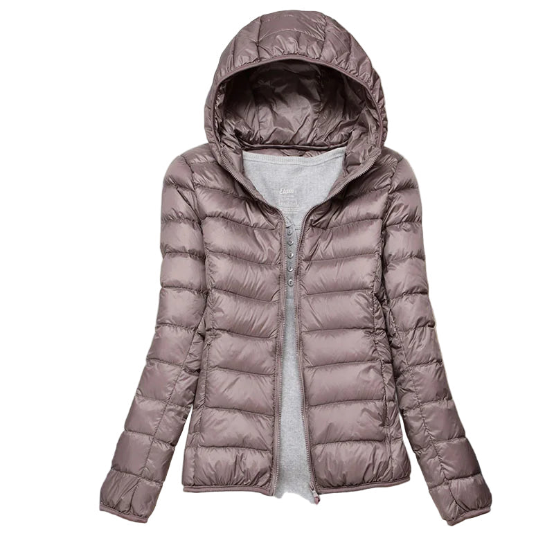"Elegant damfodrad vinterjacka med huva, modern vit design, perfekt för kalla dagar och äventyr utomhus."