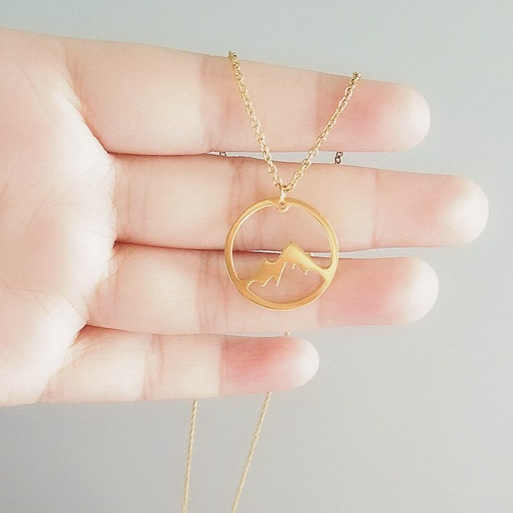 "Elegant damhalsband med bergshänge i rostfritt stål, myntformat, två snöiga bergstoppar, symbol för styrka och mod."
