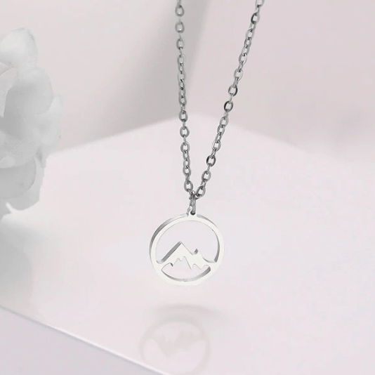 "Elegant damhalsband med bergshänge i rostfritt stål, myntformat, två snöiga bergstoppar, symbol för styrka och mod."