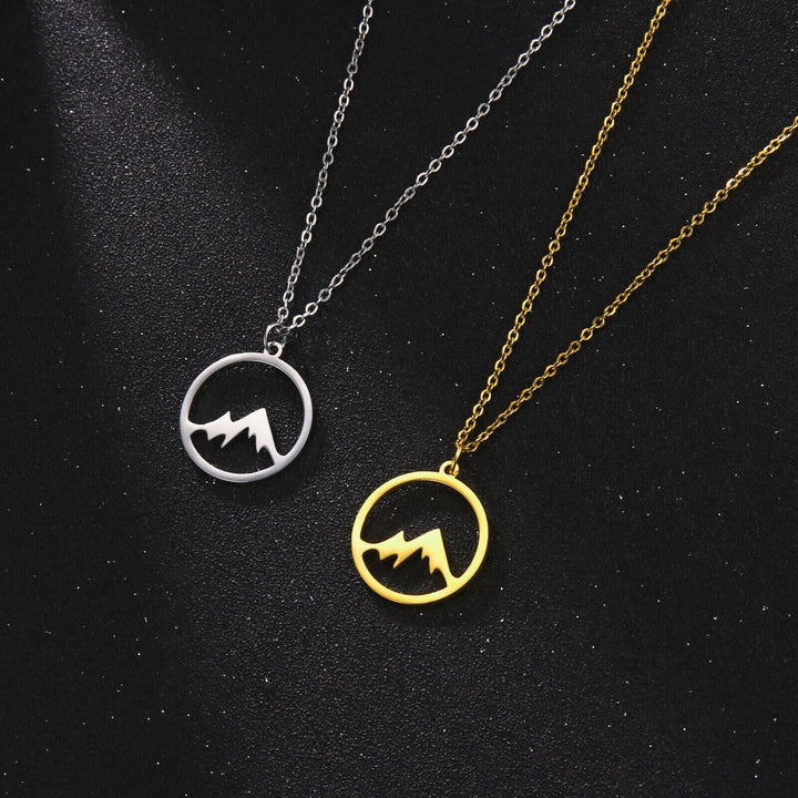 "Elegant damhalsband med bergshänge i rostfritt stål, myntformat, två snöiga bergstoppar, symbol för styrka och mod."