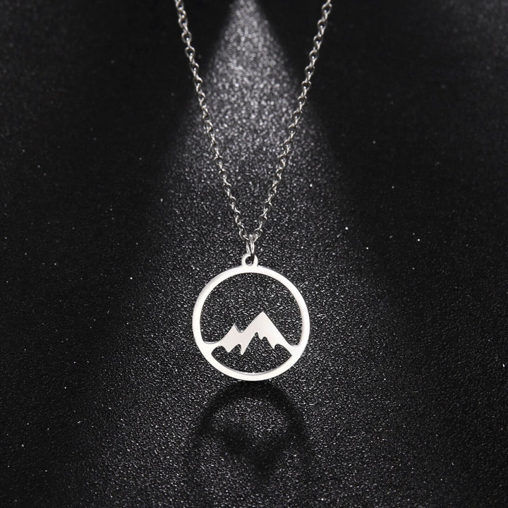 "Elegant damhalsband med bergshänge i rostfritt stål, myntformat, två snöiga bergstoppar, symbol för styrka och mod."