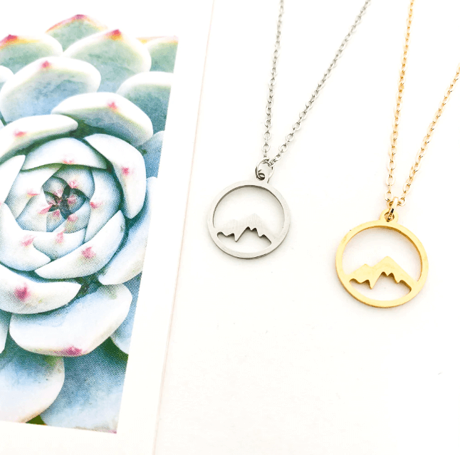 "Elegant damhalsband med bergshänge i rostfritt stål, myntformat, två snöiga bergstoppar, symbol för styrka och mod."