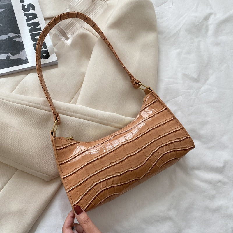 "Elegant damhandväska i konstläder, beige, med rymlig design och stilren look, perfekt för vardag och evenemang."