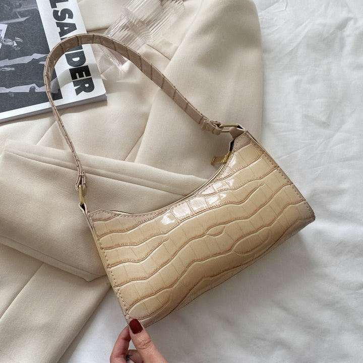 "Elegant damhandväska i konstläder, beige, med rymlig design och stilren look, perfekt för vardag och evenemang."