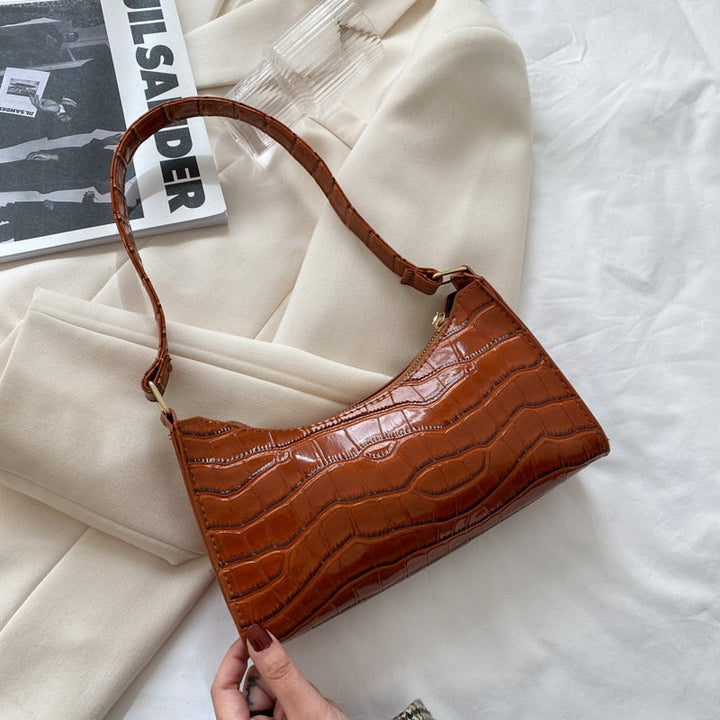 "Elegant damhandväska i konstläder, beige, med rymlig design och stilren look, perfekt för vardag och evenemang."