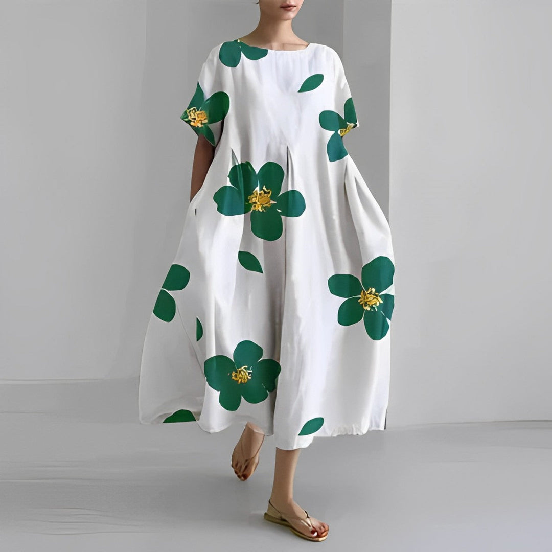 "Elegant damklänning i mjuk bomull med blommönster, figurnära passform och somrig stil, perfekt för varma dagar."