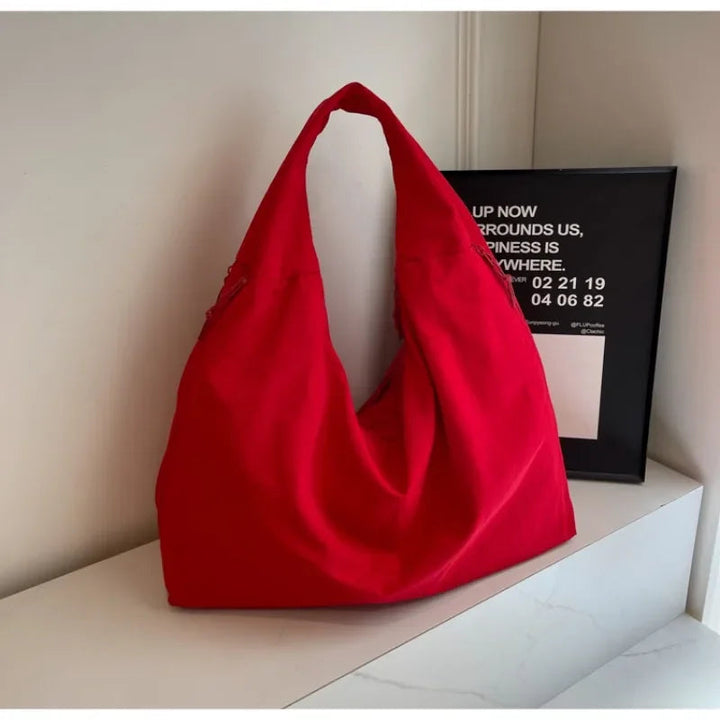 "Elegant damväska, minimalistisk design, flexibelt material, rymlig och lätt, perfekt för både arbete och fritid."