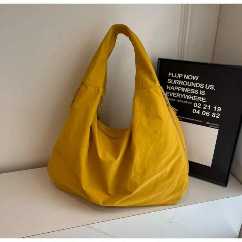"Elegant damväska, minimalistisk design, flexibelt material, rymlig och lätt, perfekt för både arbete och fritid."