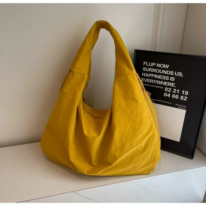 "Elegant damväska, minimalistisk design, flexibelt material, rymlig och lätt, perfekt för både arbete och fritid."