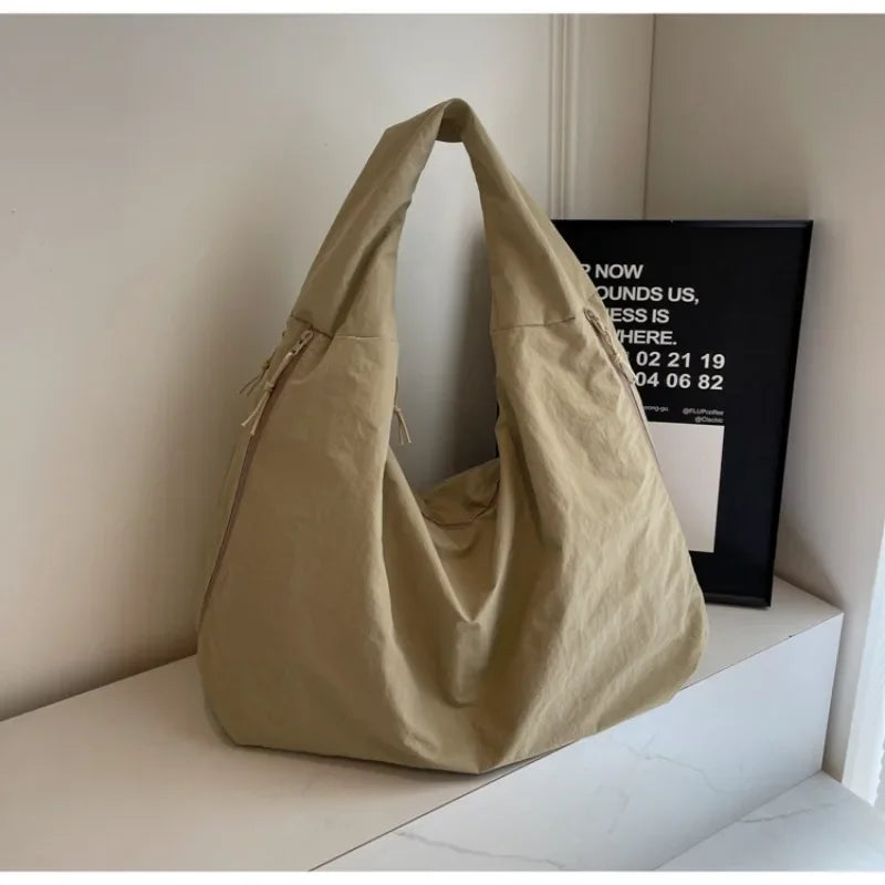"Elegant damväska, minimalistisk design, flexibelt material, rymlig och lätt, perfekt för både arbete och fritid."