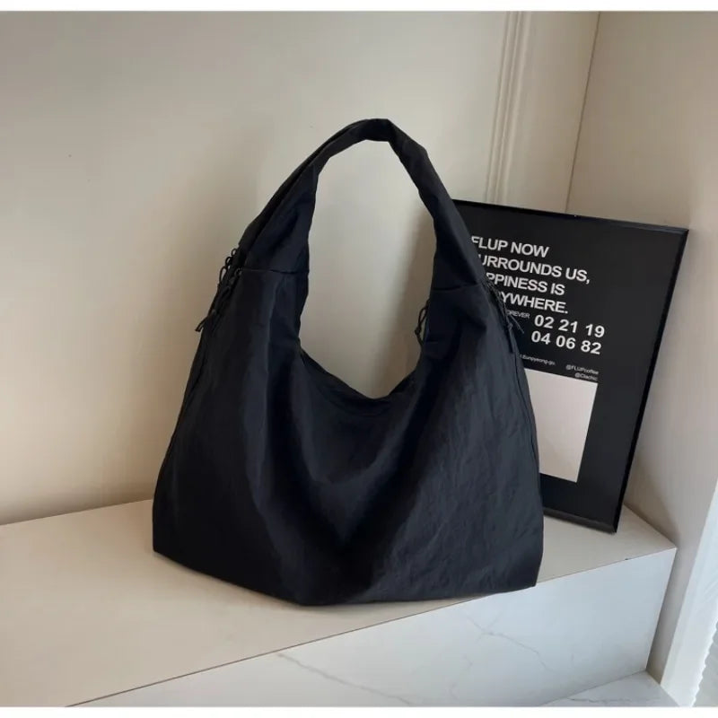 "Elegant damväska, minimalistisk design, flexibelt material, rymlig och lätt, perfekt för både arbete och fritid."