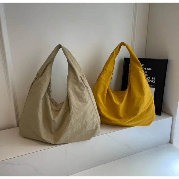 "Elegant damväska, minimalistisk design, flexibelt material, rymlig och lätt, perfekt för både arbete och fritid."