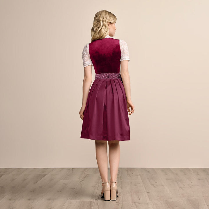 Elegant dirndl klänning med burgundy blommönster och klassiskt svart förkläde, perfekt för Oktoberfest.