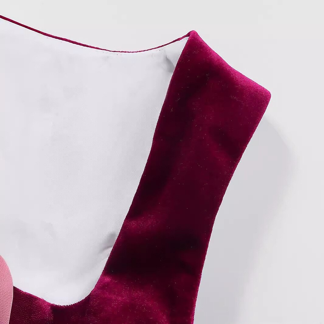 Elegant dirndl klänning med burgundy blommönster och klassiskt svart förkläde, perfekt för Oktoberfest.