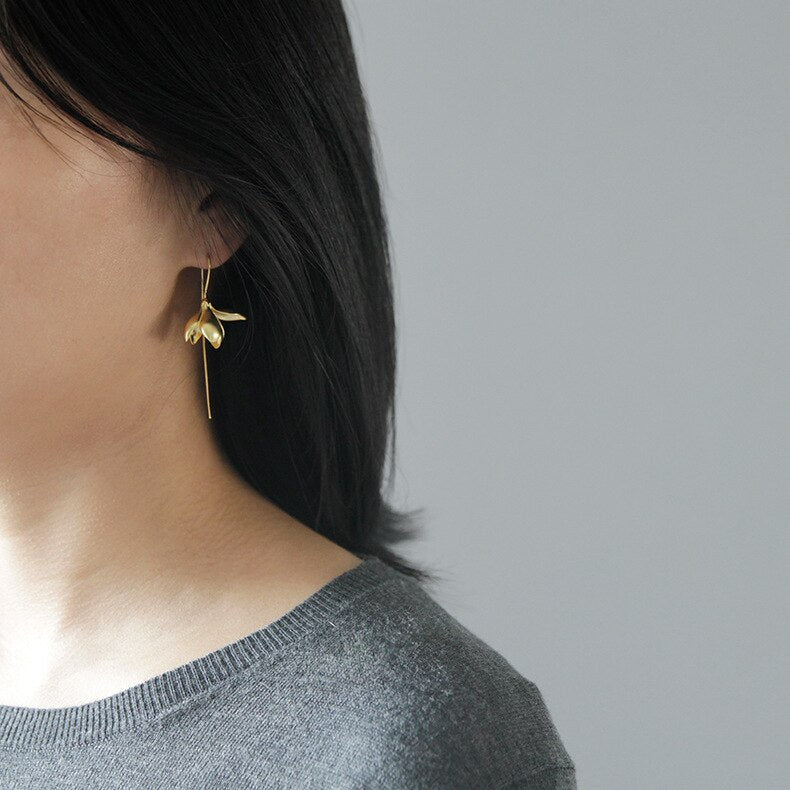 "Elegant guld och silver hinglande magnolia örhängen för kvinnor, perfekt accessoar för stil och skönhet."