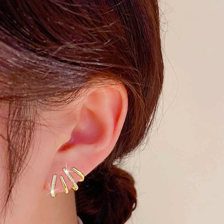 "Elegant klor örhängen med kubisk zirkonia, guldfärg, feminin design, ger illusion av flera piercingar, kvinnor."
