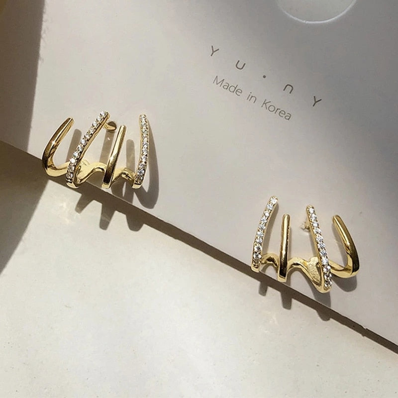 "Elegant klor örhängen med kubisk zirkonia, guldfärg, feminin design, ger illusion av flera piercingar, kvinnor."