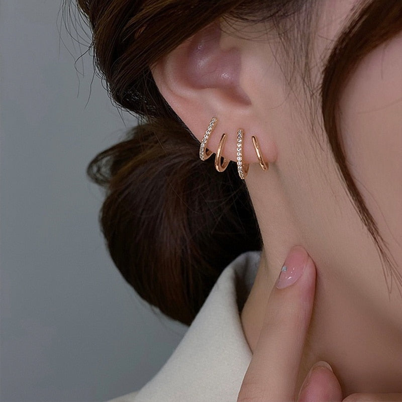 "Elegant klor örhängen med kubisk zirkonia, guldfärg, feminin design, ger illusion av flera piercingar, kvinnor."