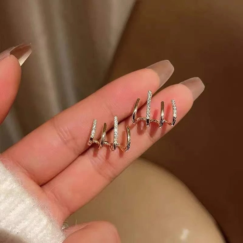 "Elegant klor örhängen med kubisk zirkonia, guldfärg, feminin design, ger illusion av flera piercingar, kvinnor."