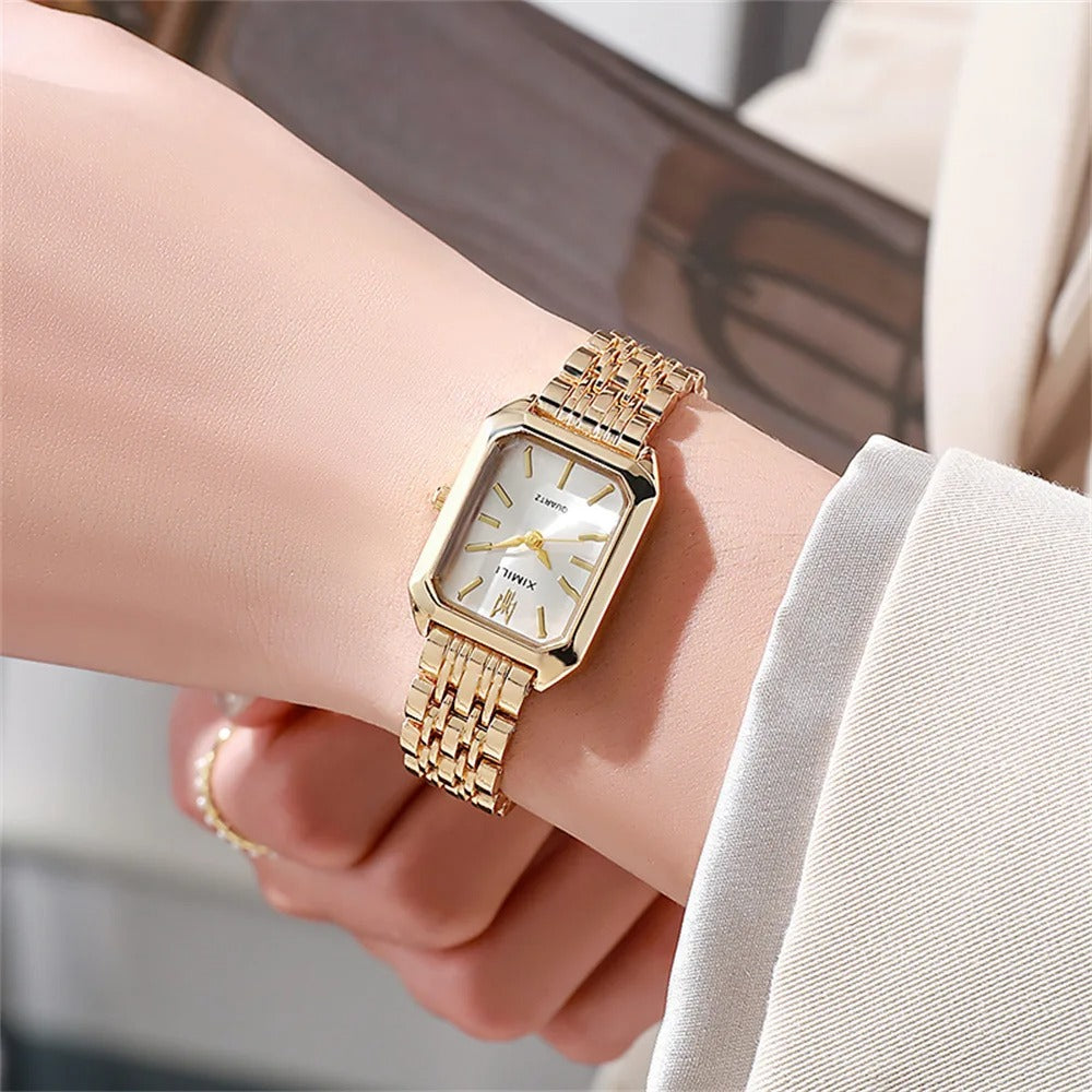 Elegant kvadratisk kvinnoarmbandsklocka i guld och silver med fyrkantig urtavla och glänsande metallarmband.