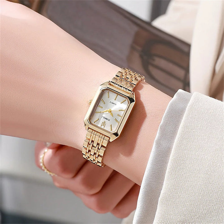 Elegant kvadratisk kvinnoarmbandsklocka i guld och silver med fyrkantig urtavla och glänsande metallarmband.