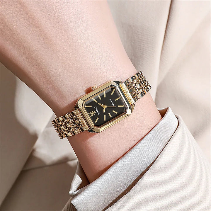 Elegant kvadratisk kvinnoarmbandsklocka i guld och silver med fyrkantig urtavla och glänsande metallarmband.