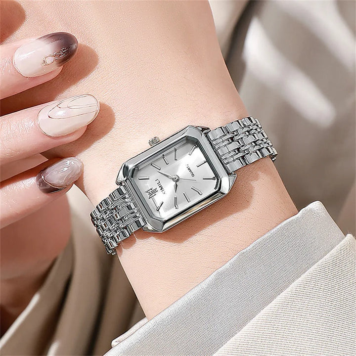 Elegant kvadratisk kvinnoarmbandsklocka i guld och silver med fyrkantig urtavla och glänsande metallarmband.