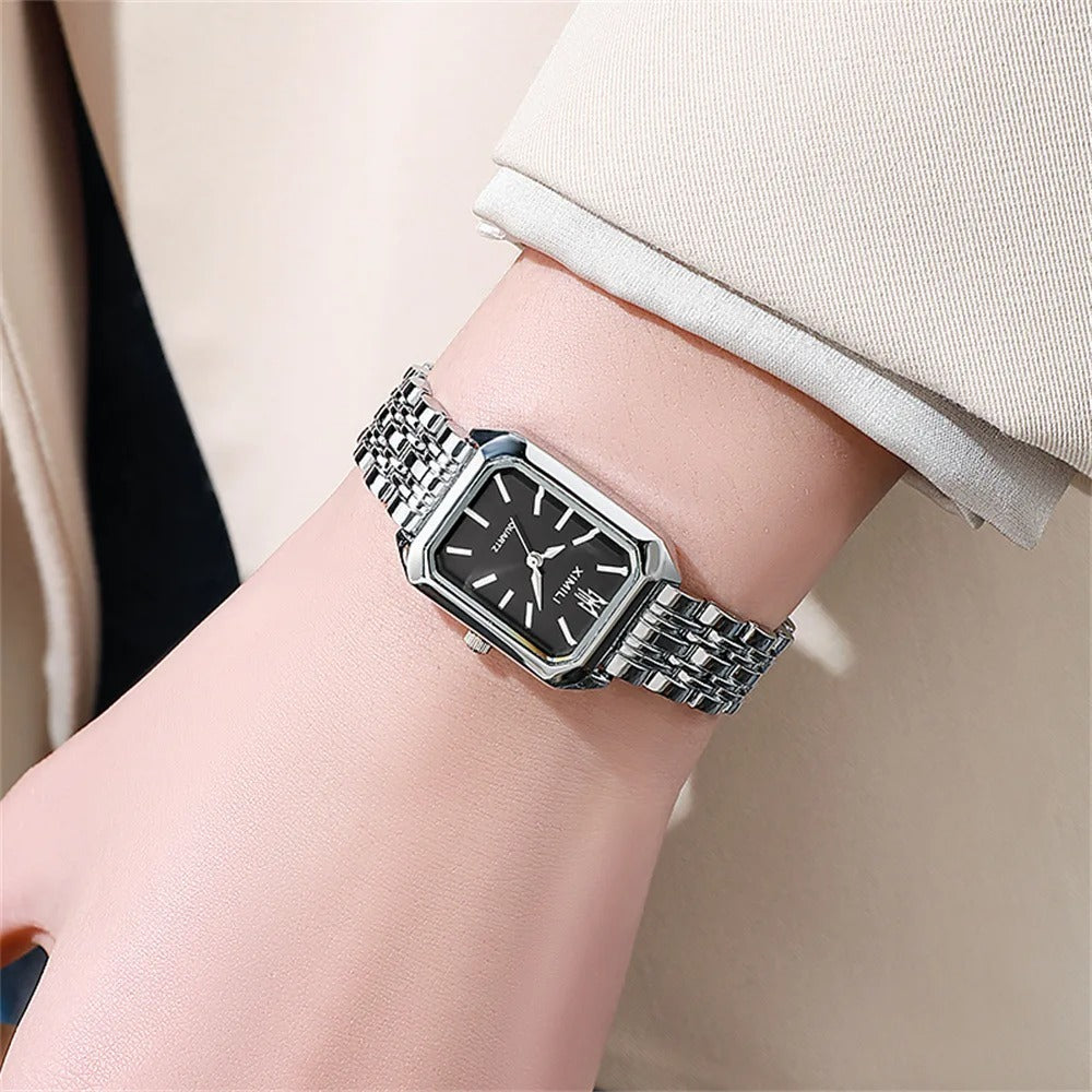 Elegant kvadratisk kvinnoarmbandsklocka i guld och silver med fyrkantig urtavla och glänsande metallarmband.