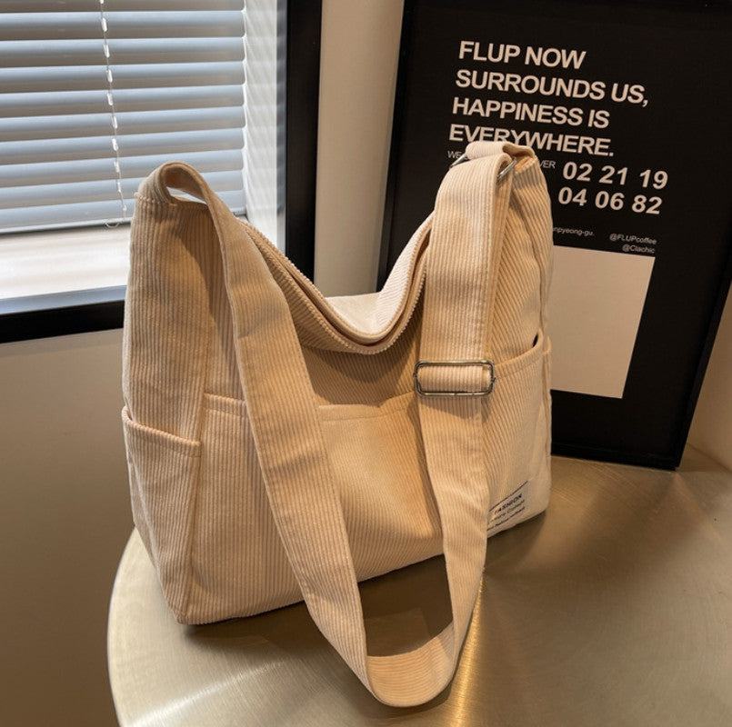 Elegant kvinnors axelväska i textil, justerbar rem, flera fickor, finns i beige, brun, grå, grön, svart.