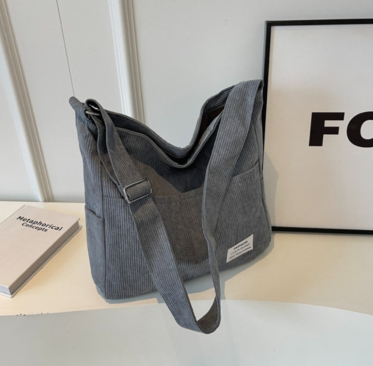 Elegant kvinnors axelväska i textil, justerbar rem, flera fickor, finns i beige, brun, grå, grön, svart.