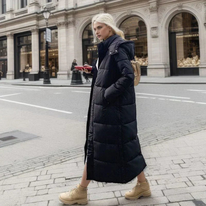 "Elegant lång vinterjacka för dam i polyester, mörk färg, stilren design, perfekt för kalla dagar och olika tillfällen."