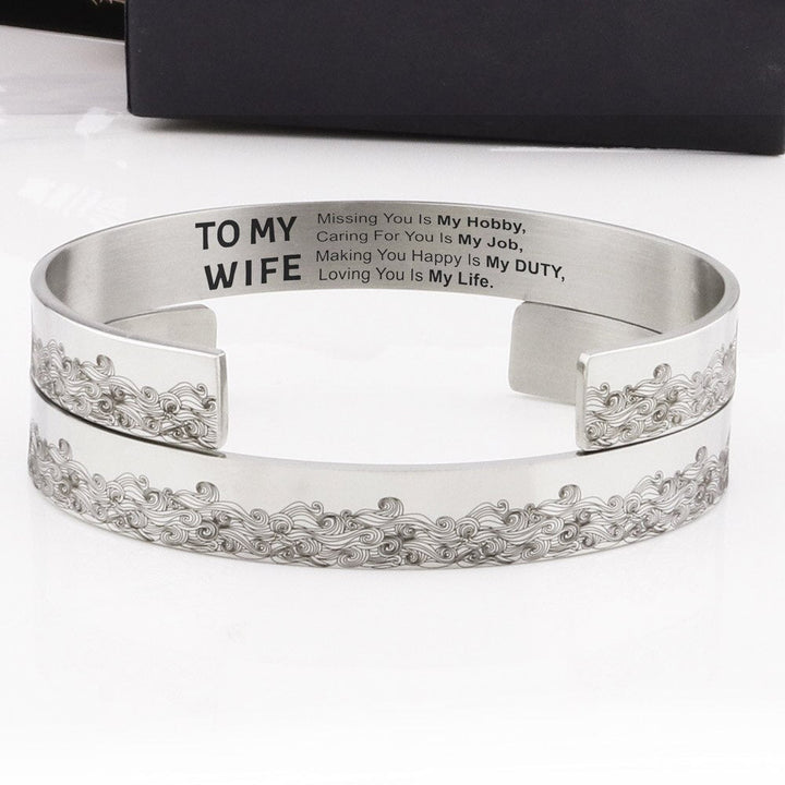 "Elegant manschettarmband av rostfritt stål för kvinnor, C-form, glansig finish, justerbar passform, stilren accessoar."