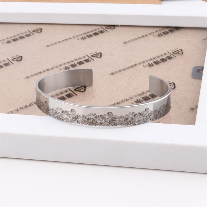"Elegant manschettarmband av rostfritt stål för kvinnor, C-form, glansig finish, justerbar passform, stilren accessoar."