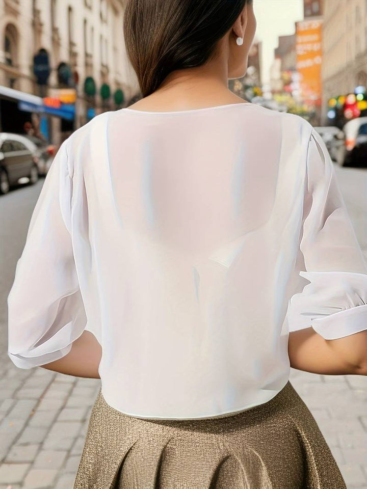 "Elegant vit damblus med öppen front och luftig design, idealisk för varmt väder, vardag och festliga sammanhang."