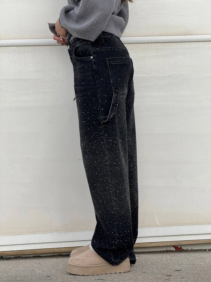 En dam som bär mörkblå jeans med diamantdetaljer, bekväm passform, perfekt för både vardag och fest.