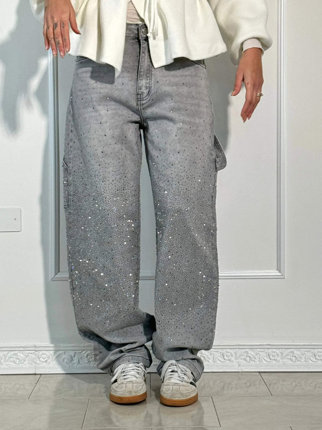 En dam som bär ljusblå jeans med diamantdetaljer, bekväm passform, perfekt för både vardag och fest.