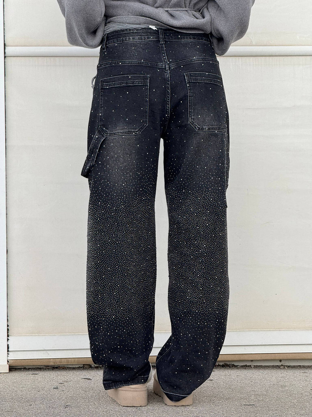 Detaljer av grå damjeans med glittrande diamantdekor, bekväm passform, perfekt för både vardag och fest.