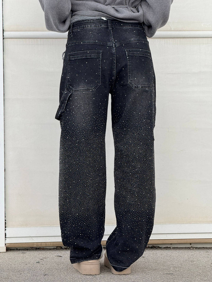 Detaljer av grå damjeans med glittrande diamantdekor, bekväm passform, perfekt för både vardag och fest.