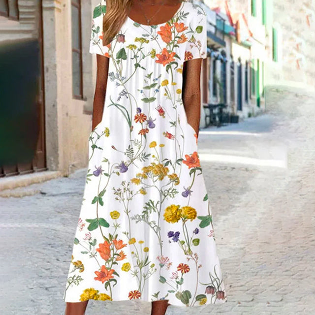 "Färgglad damernas sommarklänning med blommönster, korta ärmar och avslappnad passform perfekt för varma dagar."