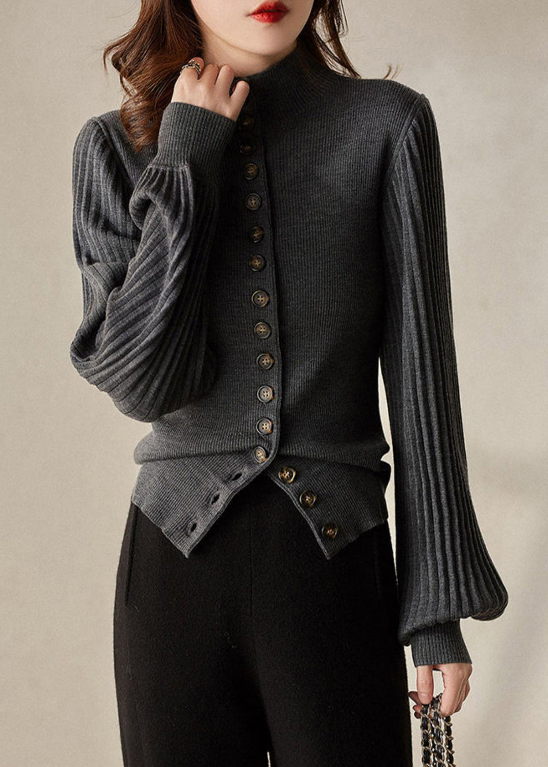 "Grå och svart stickad damtopp med ståkrage och lanternärm i mjukt material, modern elegant stil."
