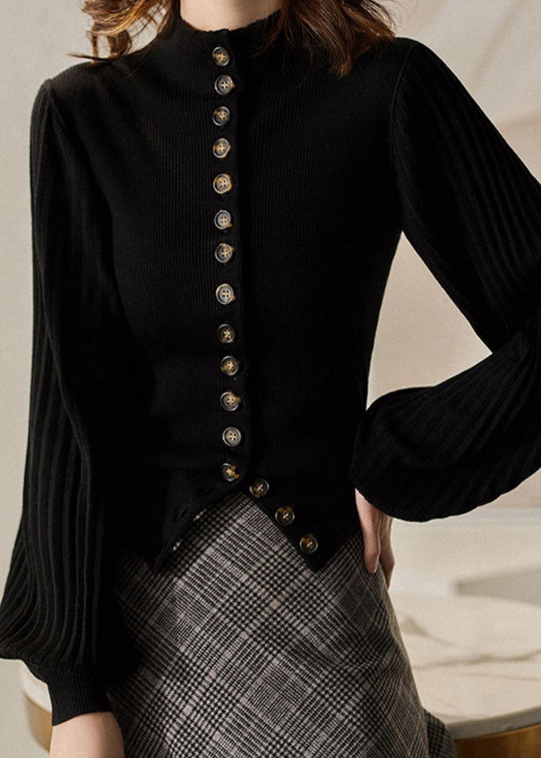 "Grå och svart stickad damtopp med ståkrage och lanternärm i mjukt material, modern elegant stil."