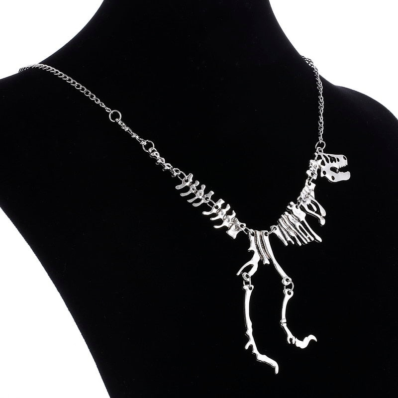 "Halsband med detaljerat T-Rex-skelett, rörlig design i brons och guld. Perfekt för damer som älskar dinosaurier."