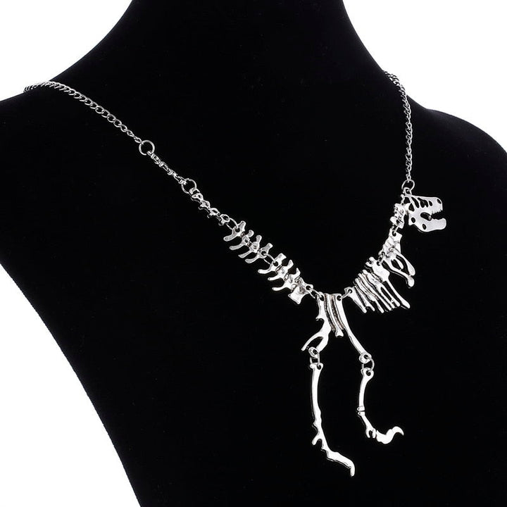 "Halsband med detaljerat T-Rex-skelett, rörlig design i brons och guld. Perfekt för damer som älskar dinosaurier."