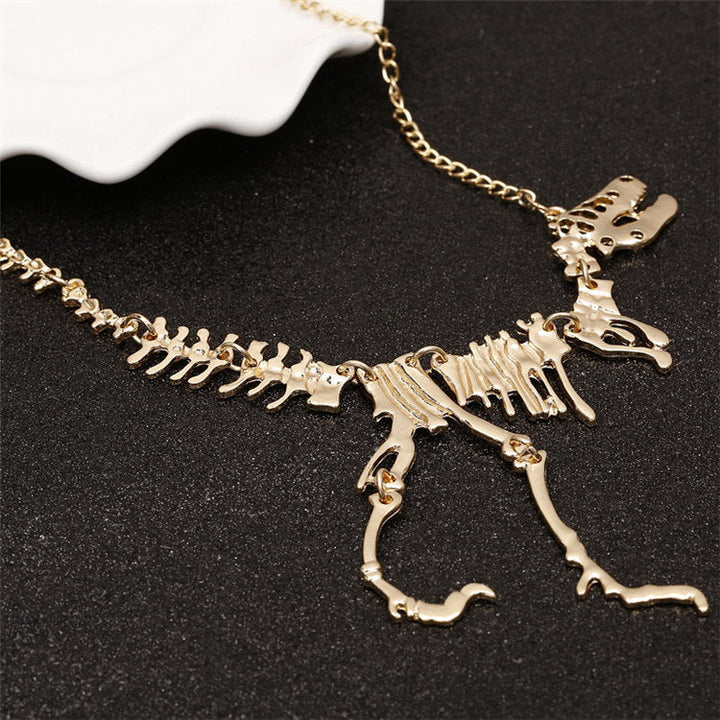 "Halsband med detaljerat T-Rex-skelett, rörlig design i brons och guld. Perfekt för damer som älskar dinosaurier."