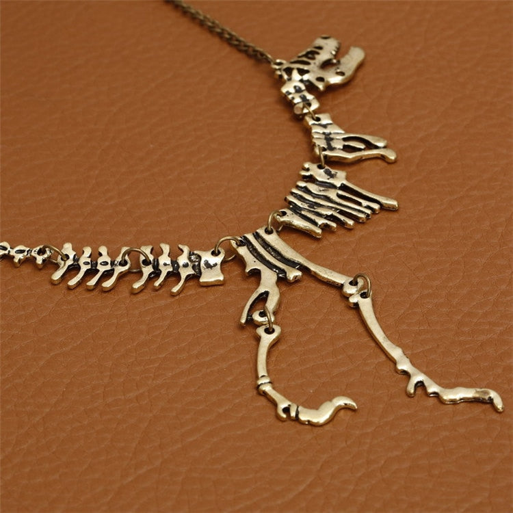 "Halsband med detaljerat T-Rex-skelett, rörlig design i brons och guld. Perfekt för damer som älskar dinosaurier."