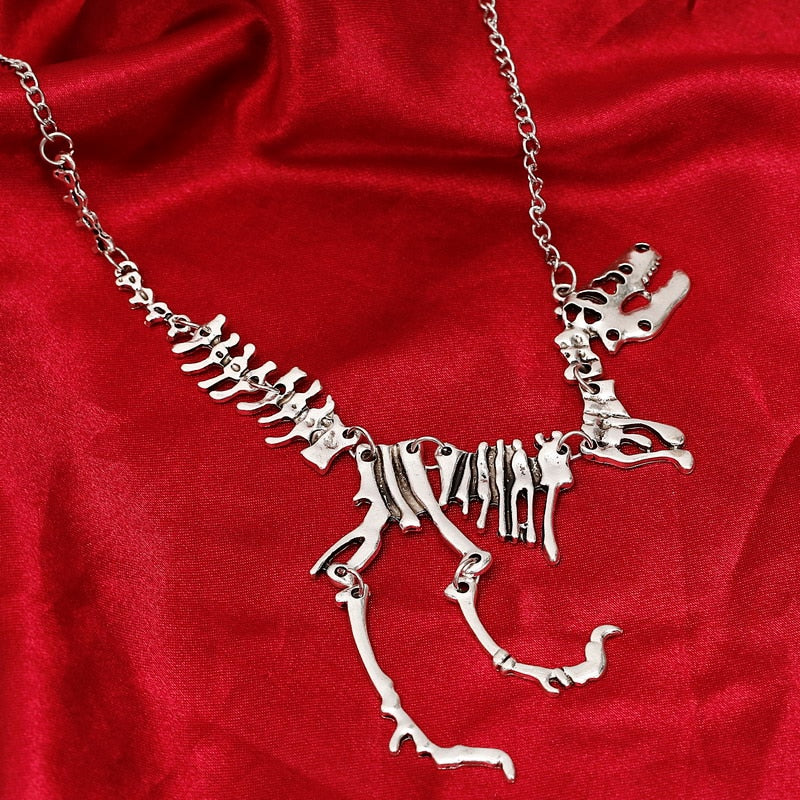 "Halsband med detaljerat T-Rex-skelett, rörlig design i brons och guld. Perfekt för damer som älskar dinosaurier."