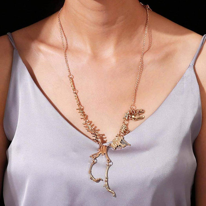 "Halsband med detaljerat T-Rex-skelett, rörlig design i brons och guld. Perfekt för damer som älskar dinosaurier."