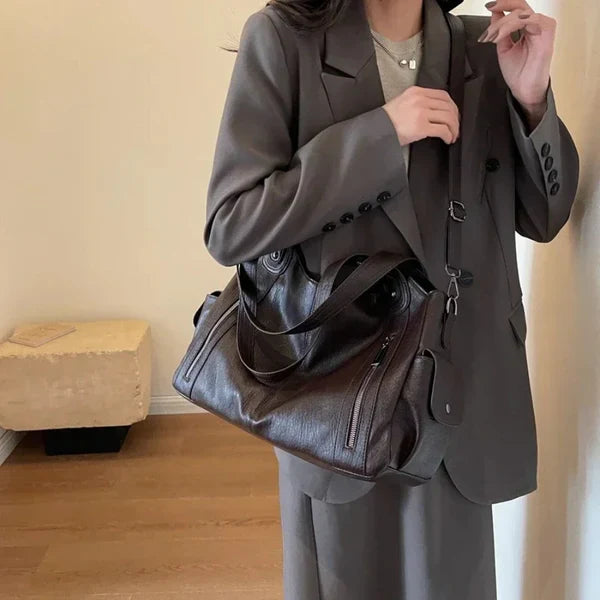 Handgjord lädertygväska för kvinnor med rymlig interiör, justerbara remmar, elegant design, perfekt för alla tillfällen.