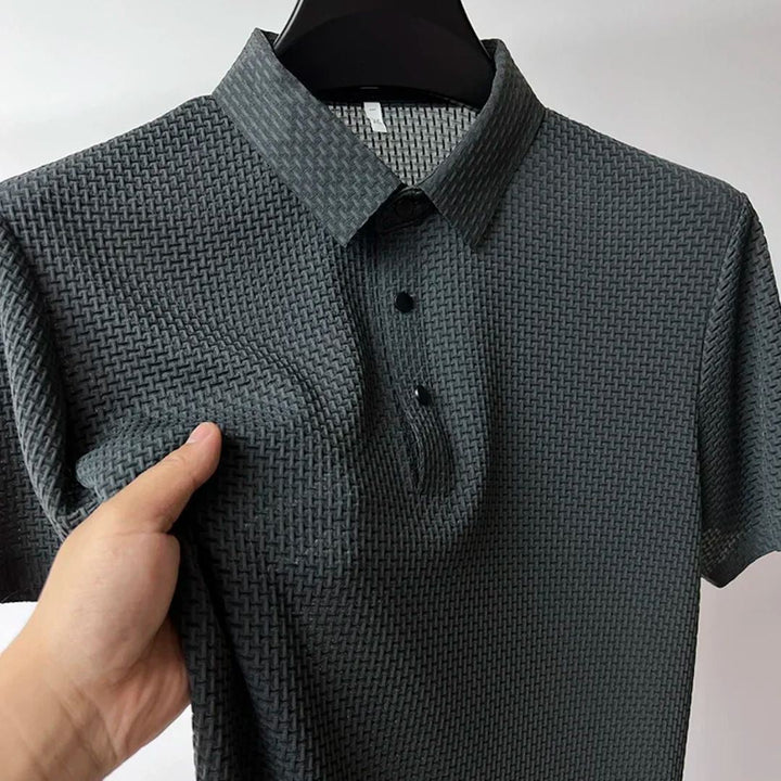 "Herr kortärmad andningsbar polo T-shirt i grått, framifrån med klassisk krage och tre-knapps placket."