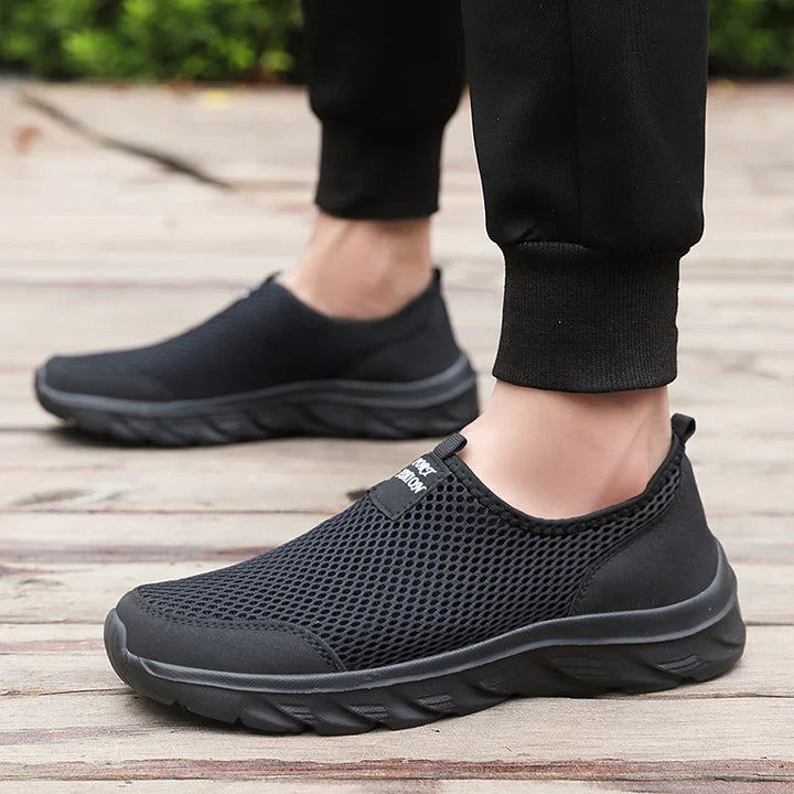 "Herrens slip-on sneakers i andningsbart material med robust gummisula, stilren design för vardag och utomhusbruk."